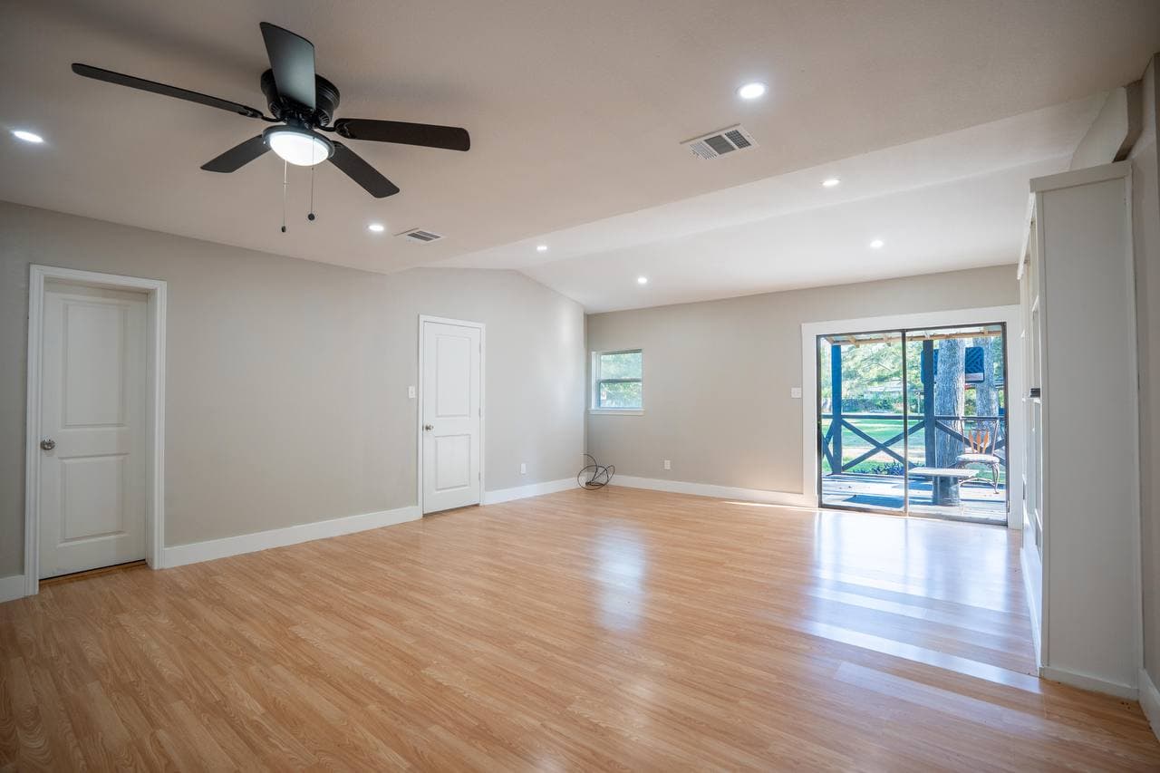 Renovated living area with recessed lighting and sliding door