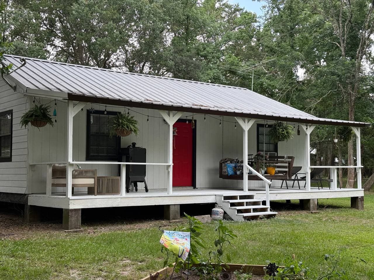 Farmhouse exterior renovation with covered porch and metal roof