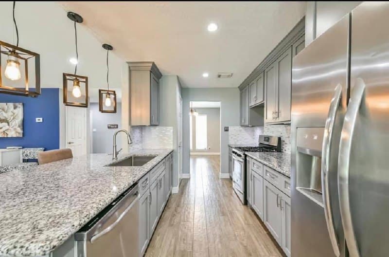 Kitchen renovation with gray cabinets and stainless steel appliances